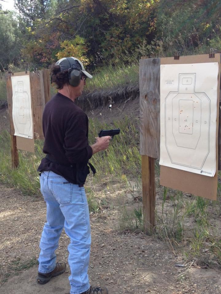 Student inspecting a paper silhouette target after a string