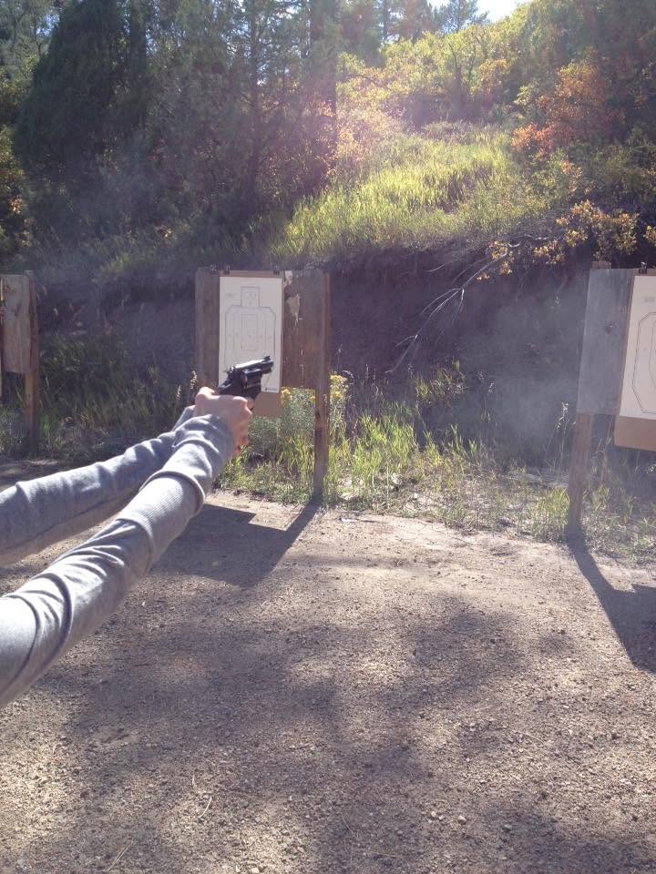 First-person view of a pistol fired, smoke drifting downrange