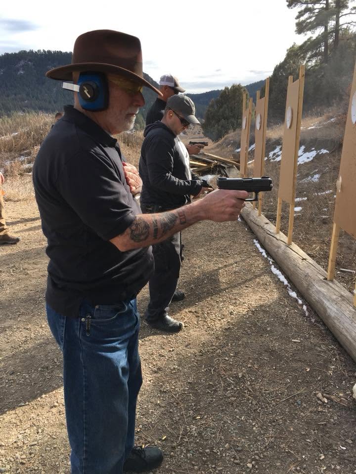 Long-time shooter in a cowboy hat squared up on his target