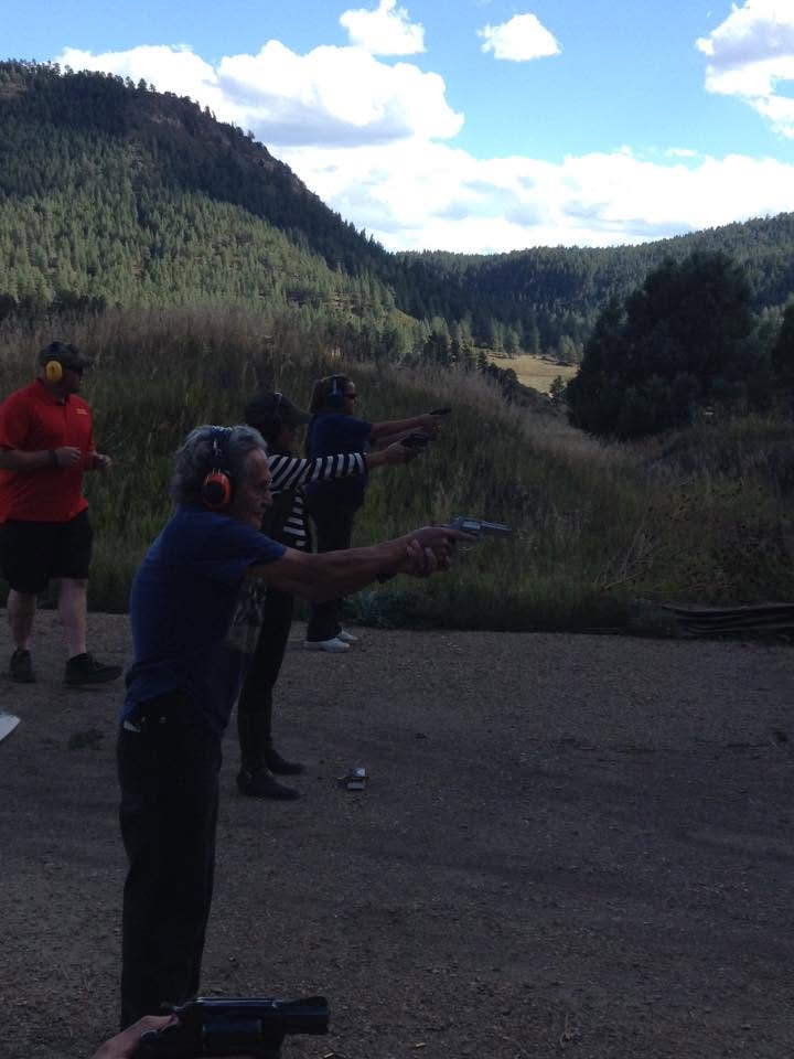 Three students on the line, instructor behind, mountains beyond