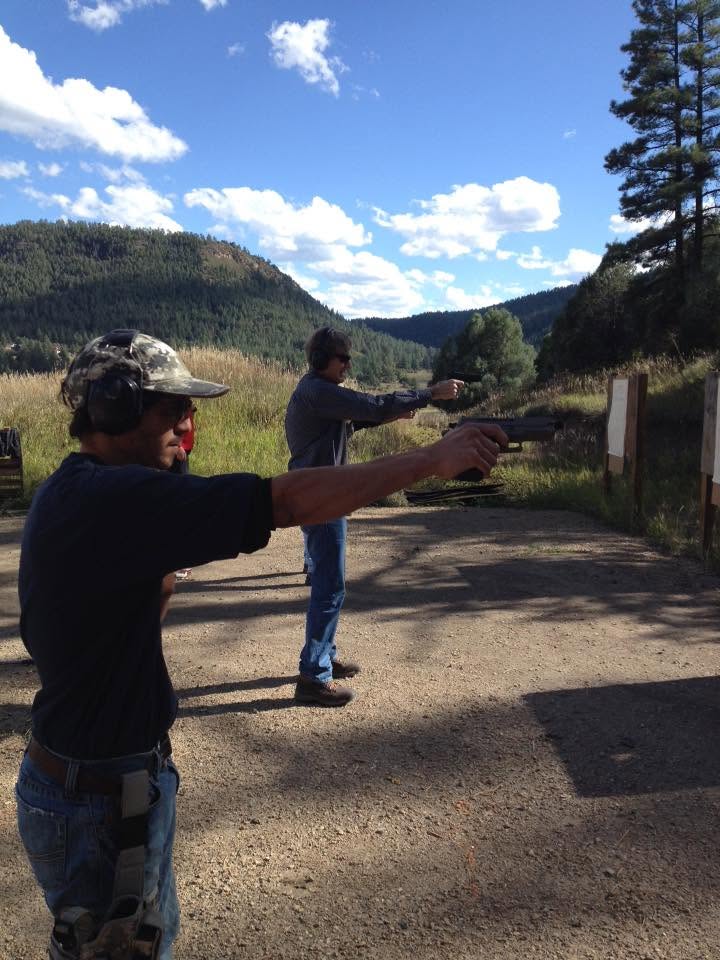 Two students on the firing line above a Colorado valley