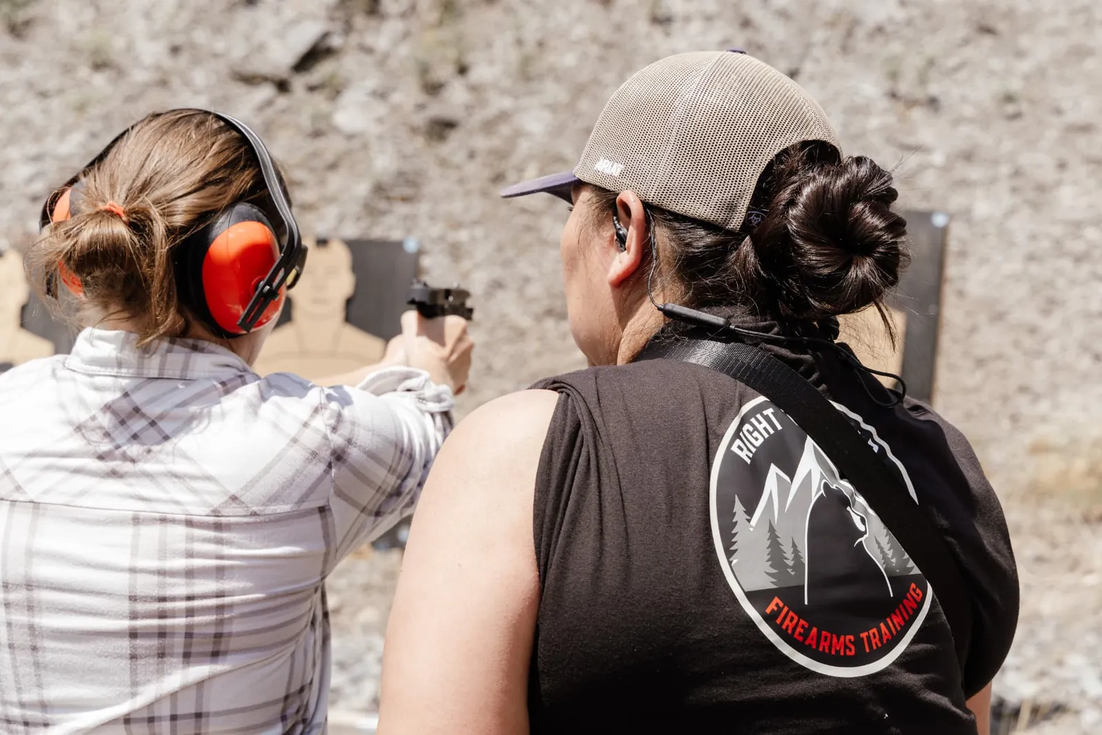 Instructor coaching a student one-on-one behind the pistol