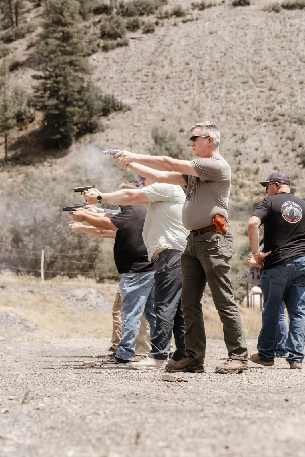 Student running a revolver on the line while the class shoots