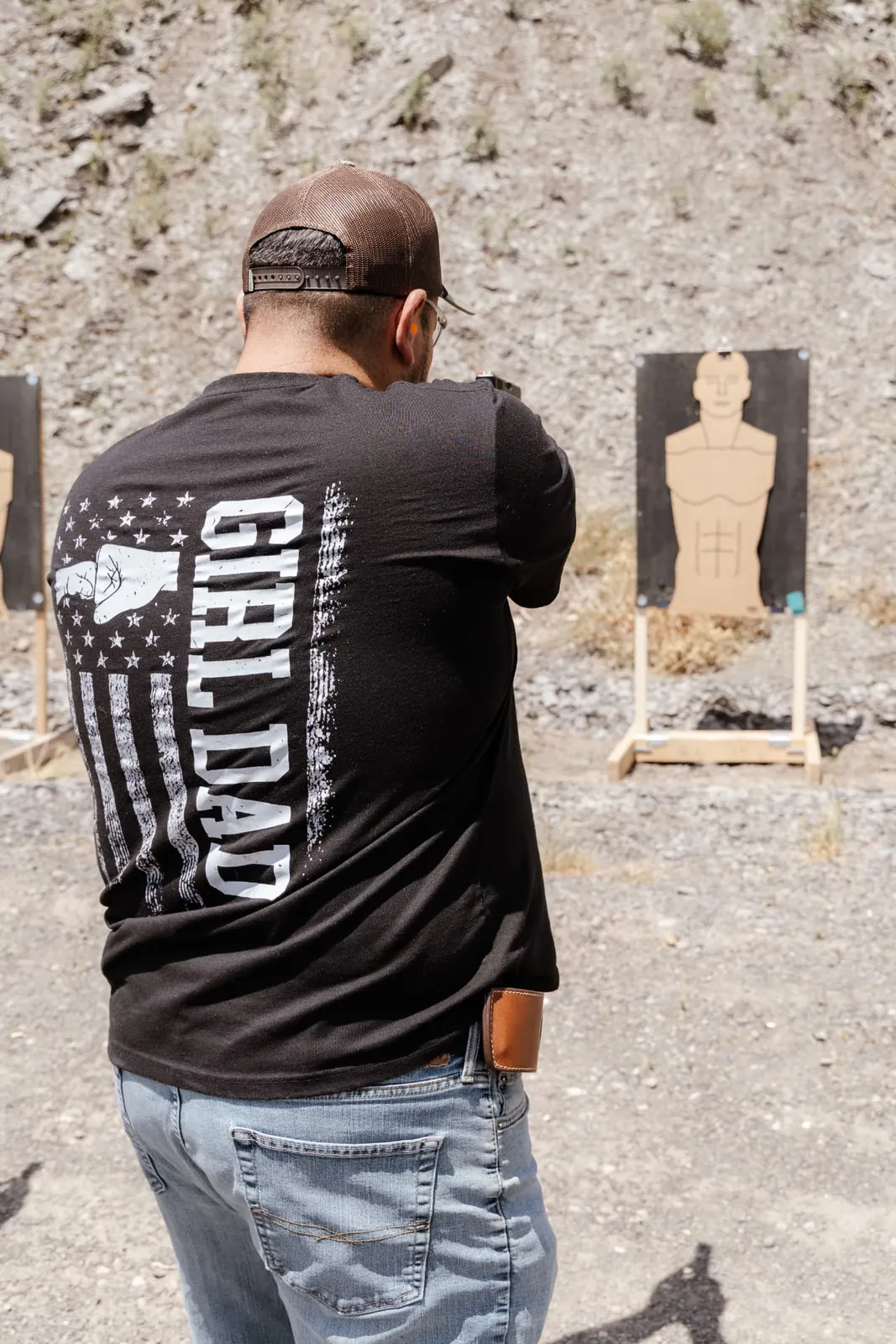 Student shooting at a paper silhouette target on the range
