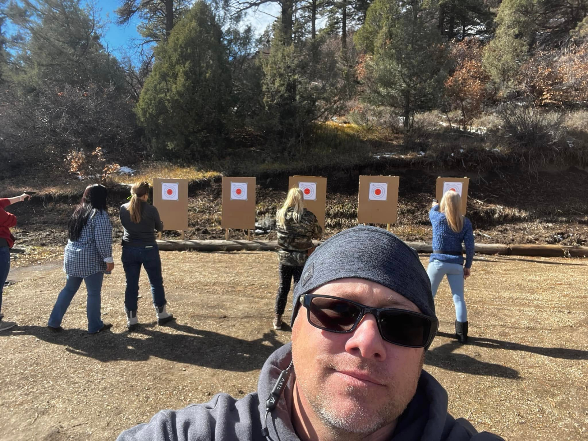 Instructor on the range with students shooting bullseye targets behind him