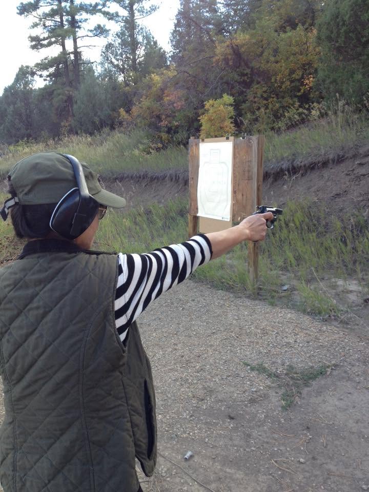 Student shooting a revolver one-handed at a paper target